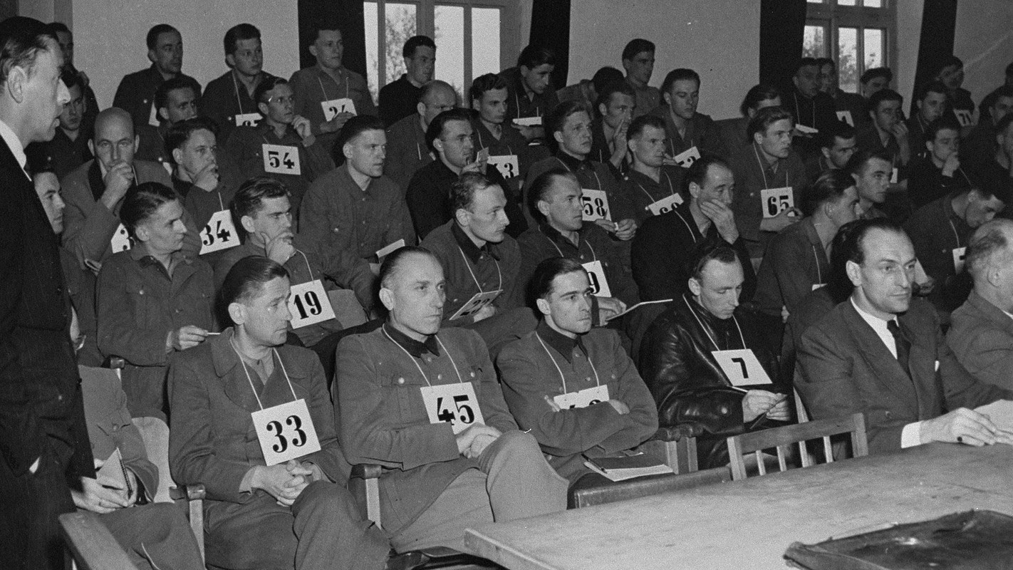 SS Gen Kraemer 33, SS Gen Priess 45 and SS Col Peiper, 3rd from left front row, at the Malmedy Massacre Trial CREDIT National Archives and Records Administration