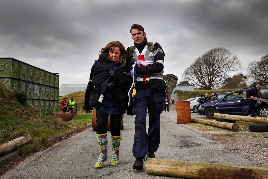 HMS Kent sailor with civilian at disaster relief exercise