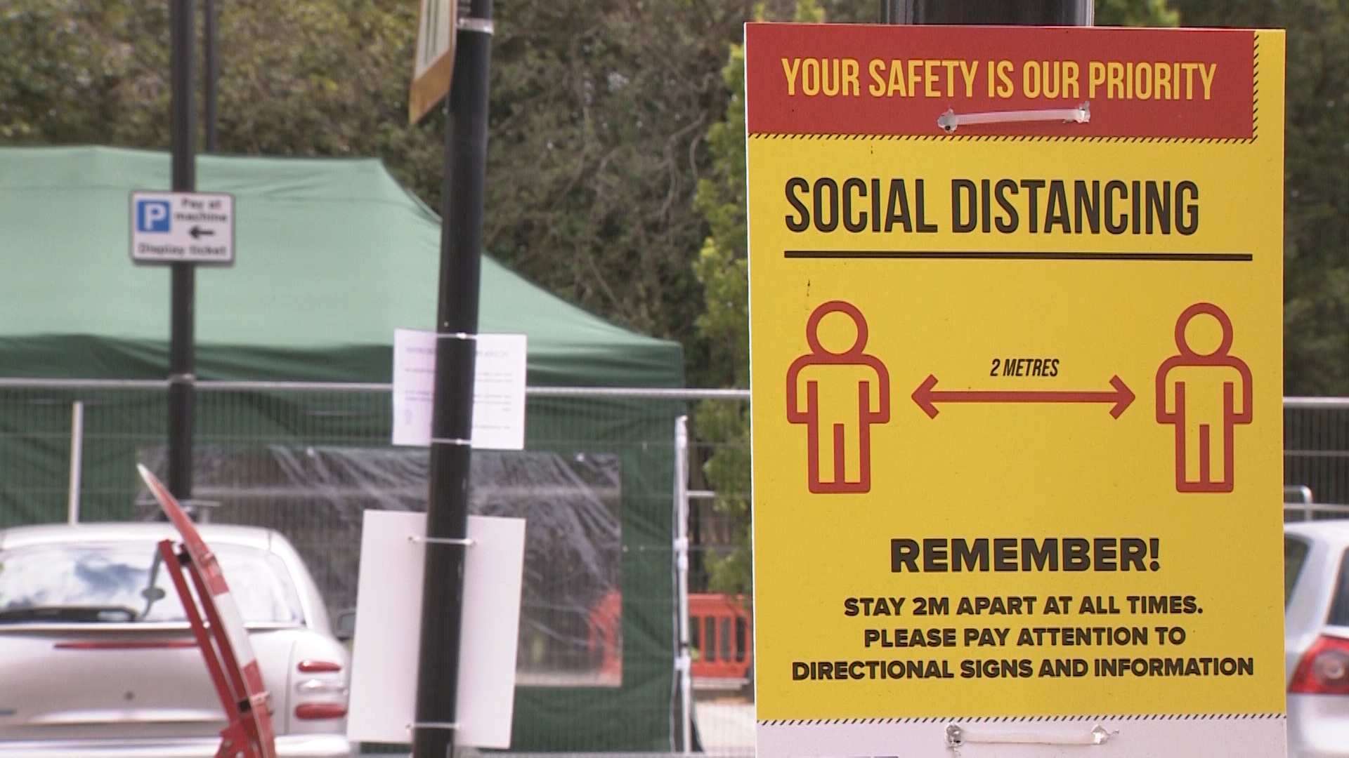 Social distancing sign near mobile testing unit in Leicester.