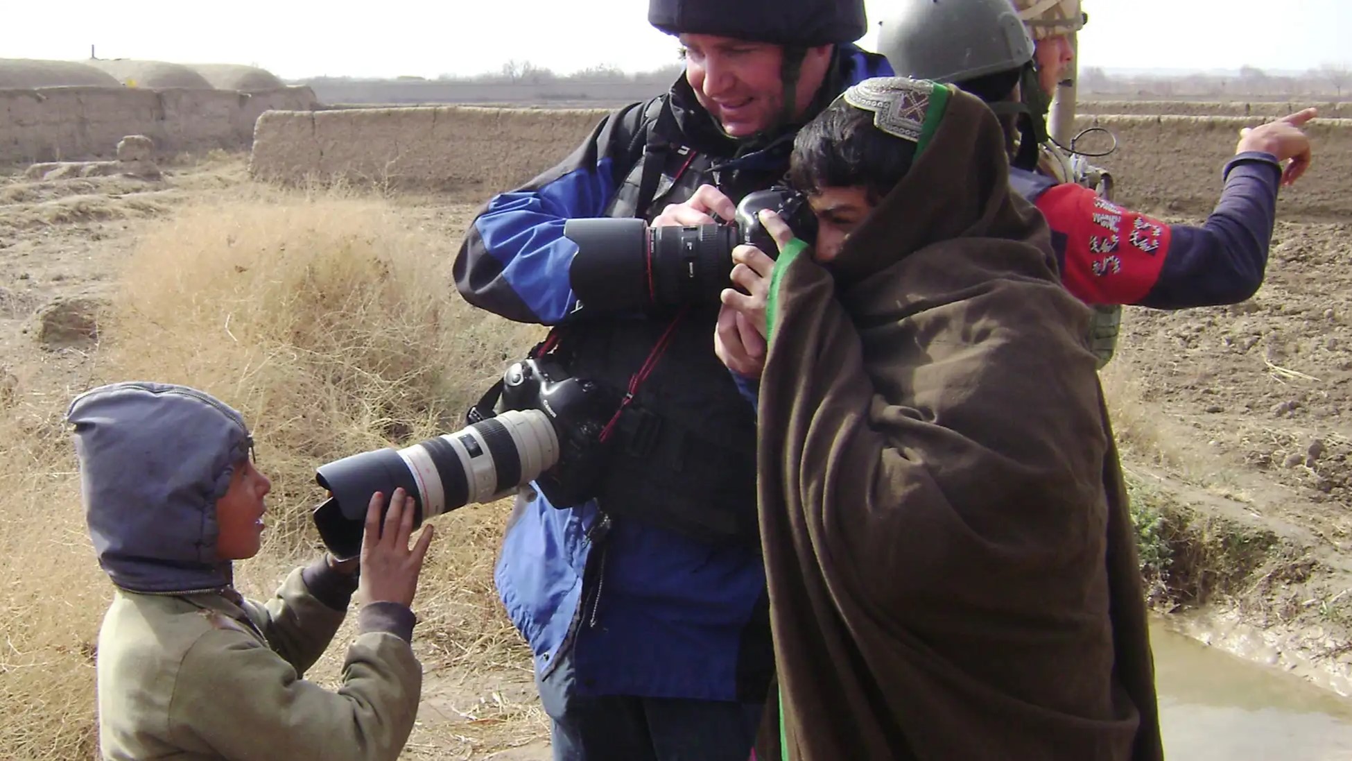Soldier Magazine journalist is seen in the Middle East helping a child take a photo of another child CREDIT Soldier Magazine