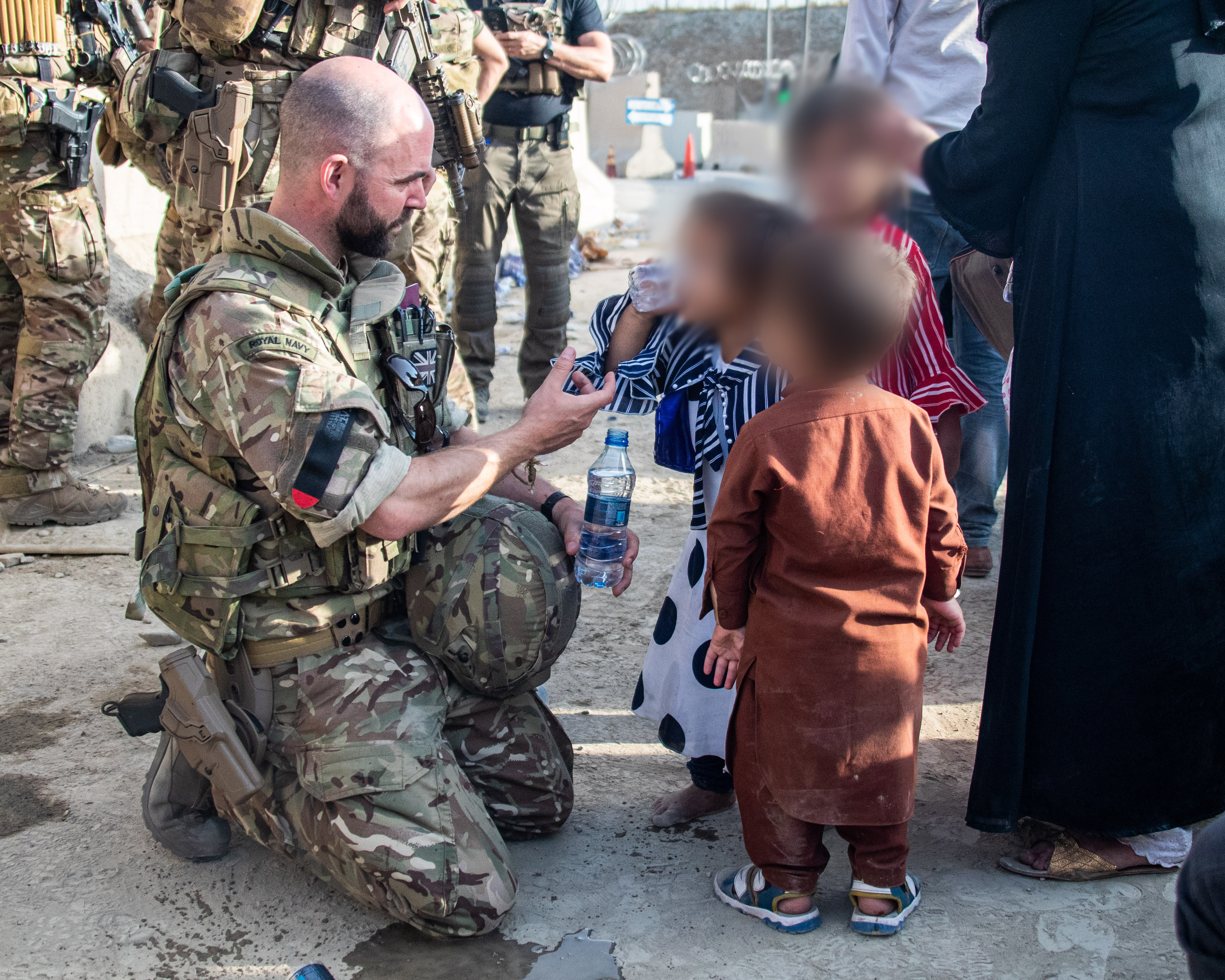 A soldier feeds children as part of the operation (Picture: MOD).