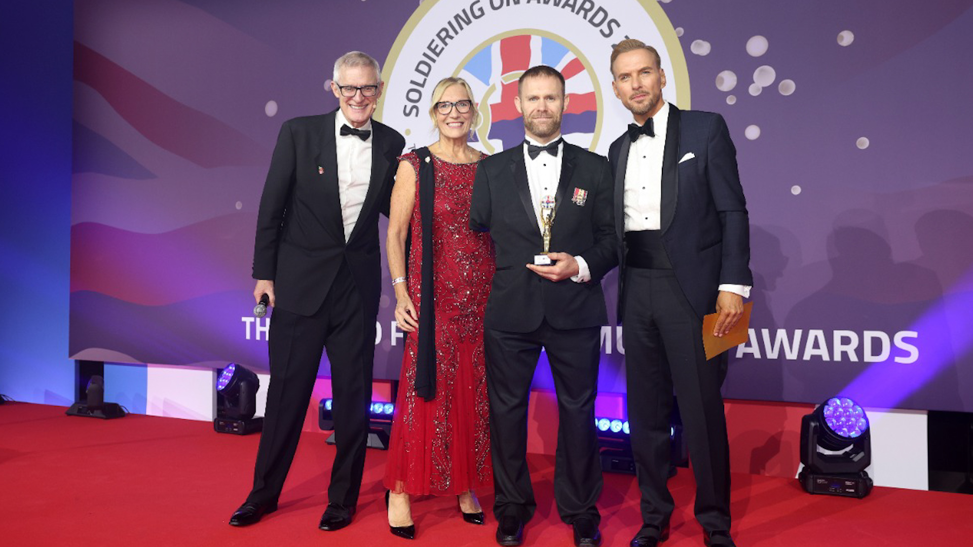 Soldiering On Awards 2025- Host Jeremy Vine, and award sponsor Julie Baker from NatWest celebrated with Inspirational Award winner Mark Ormrod MBE and singer Matt Goss, who presented the accolade. Credit Soldiering on awards 23.10.25
