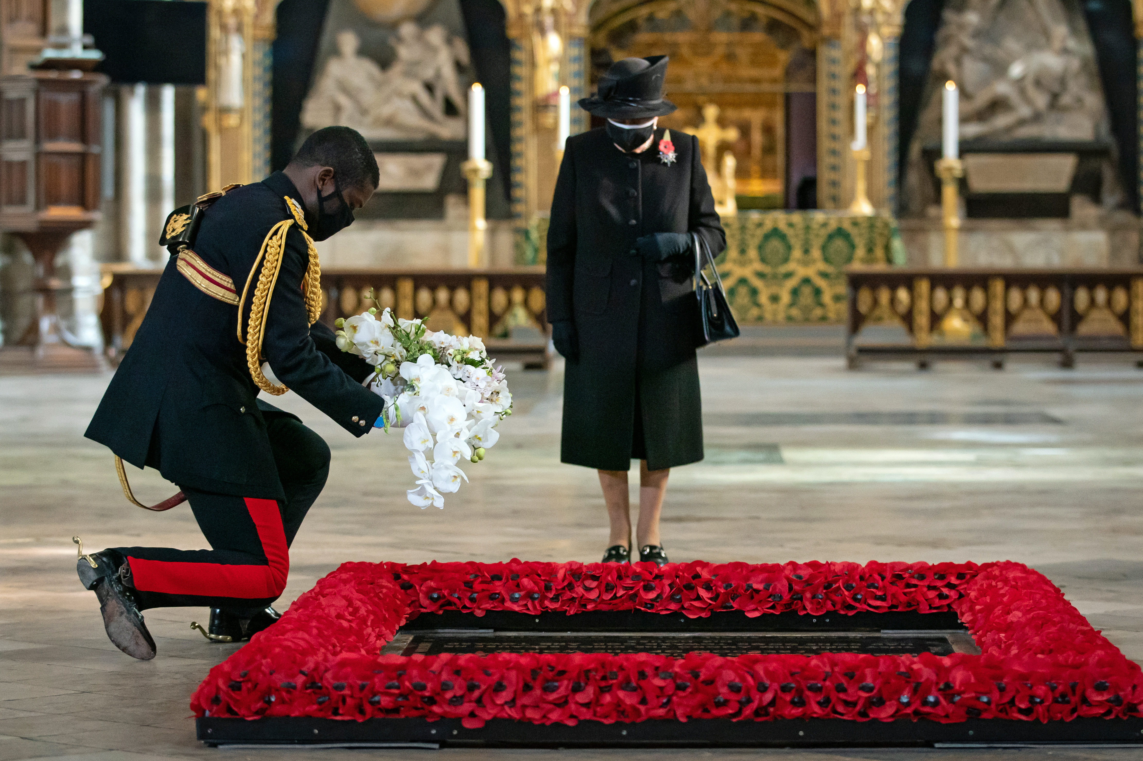 The Queen's Equerry, Lieutenant Colonel Nana Kofi Twumasi-Ankrah, places a bouquet of flowers at the grave of the Unknown Warrior on behalf of Queen Elizabeth II during a ceremony in London's Westminster Abbey 071120 CREDIT PA.
