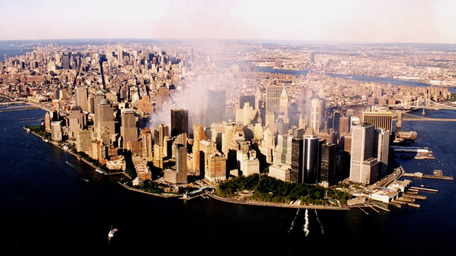 The World Trade Center complex continues to burn, while the Coast Guard Cutter Tahoma controls vessel traffic in New York harbor September 15