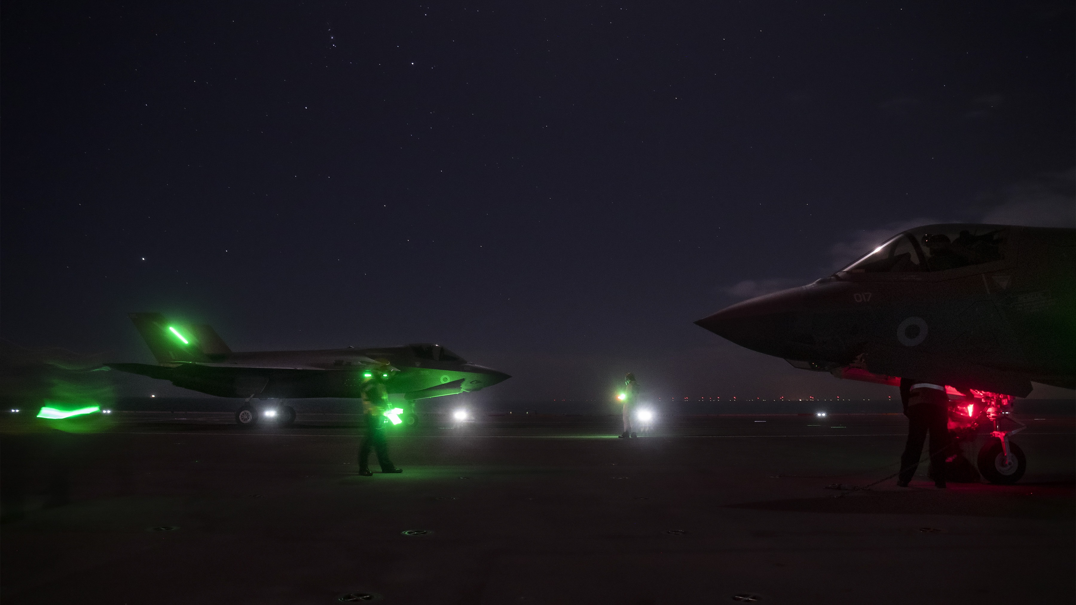 The jet's bright green lights seen clearly against the dark of night on board HMS Queen Elizabeth (Picture: MOD).