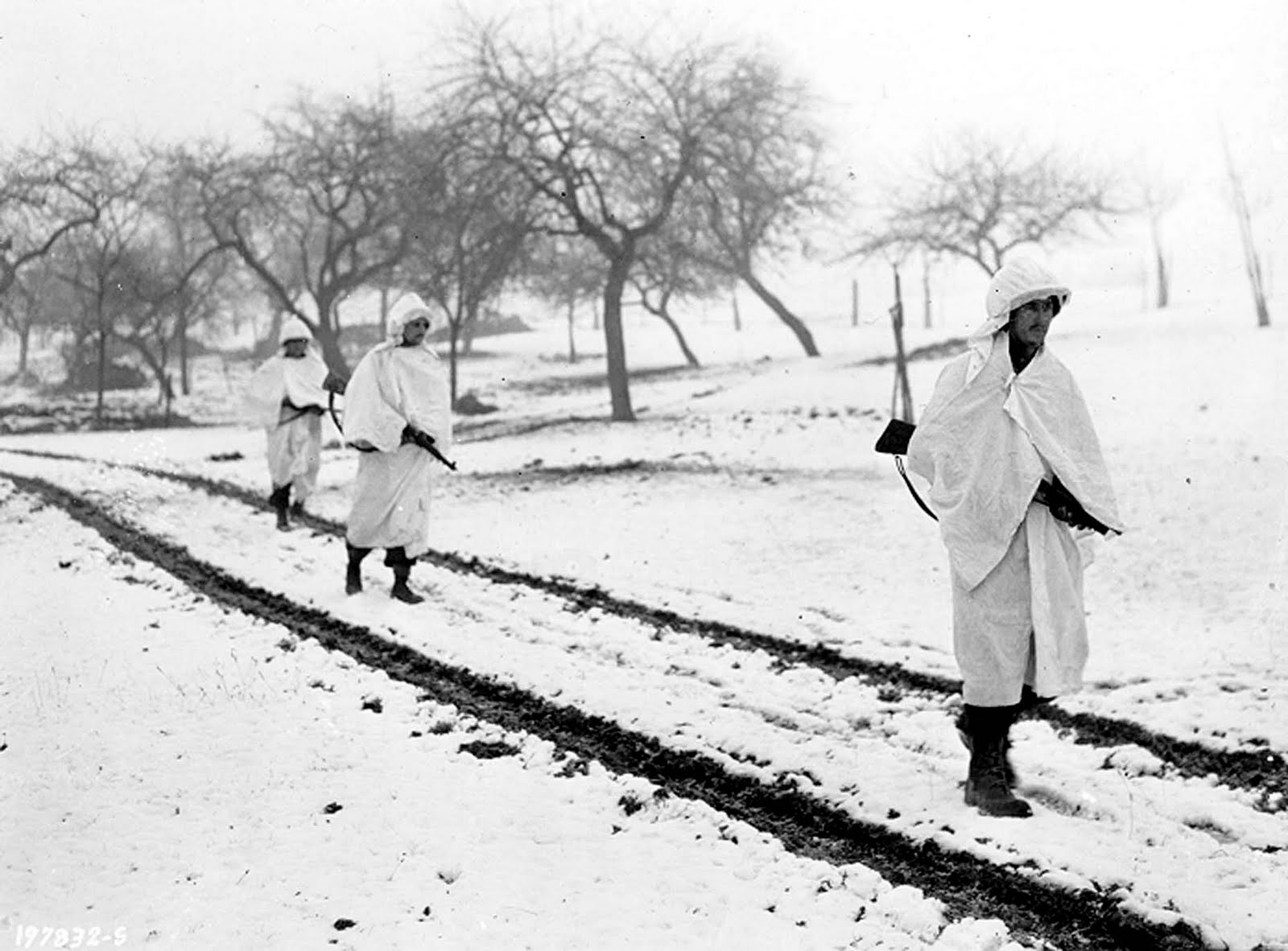 Three US soldiers cross a snow-covered field in Lellig, Luxembourg in December 1944 wearing white bedsheets to camouflage them in the snow CREDIT US Army