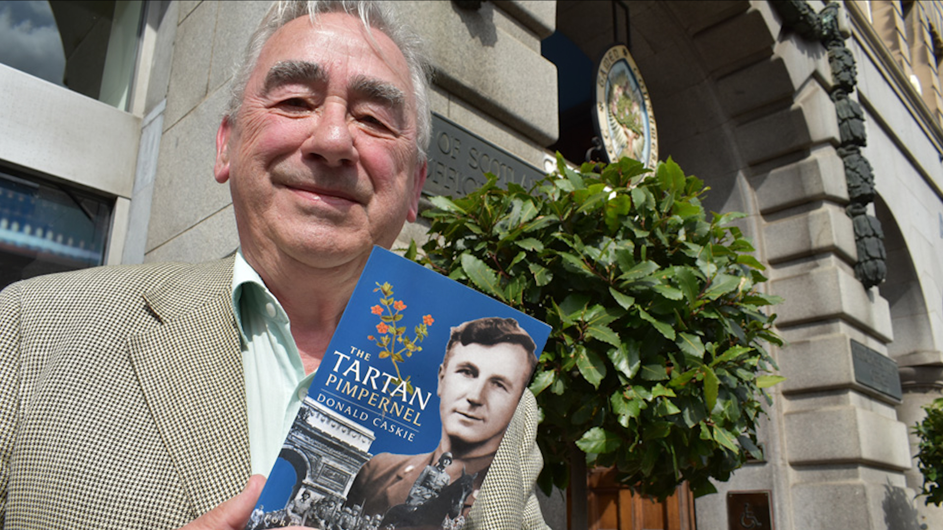 Tom Caskie posing with his uncle's book The Tartan Pimpernel 261019 CREDIT Church of Scotland.jpg 