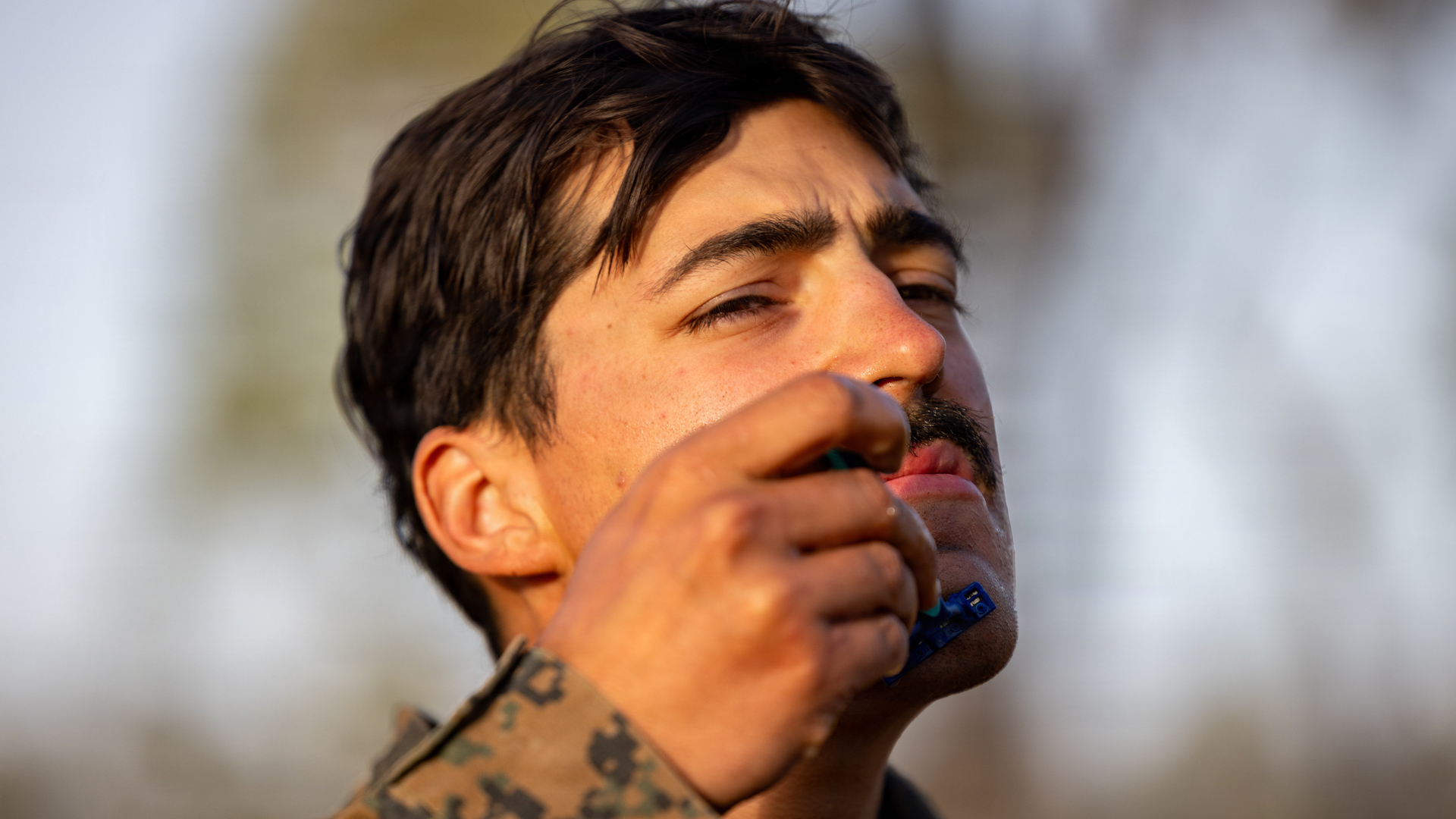 A US Marine Corps sergeant keeps on the corps' good side as he shaves during an exercise (Picture: US Department of War)