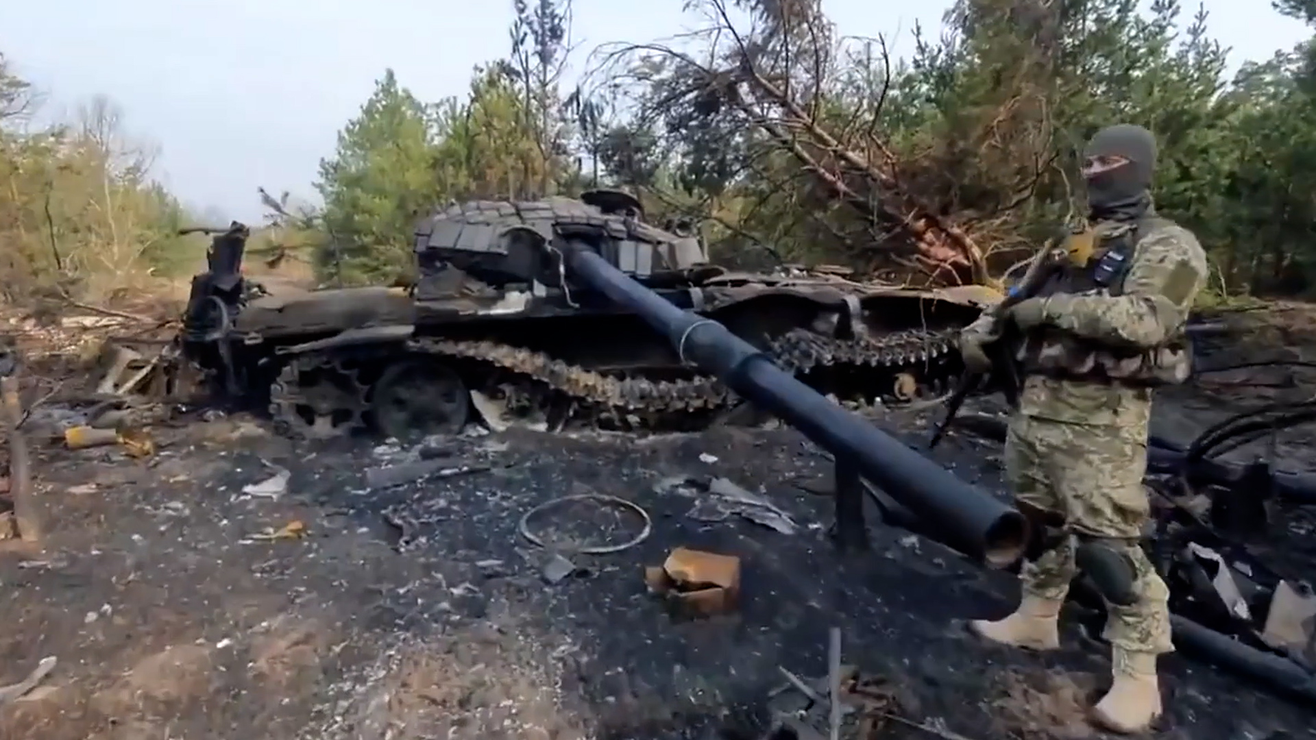 A member of the Ukrainian Armed Forces stands beside a destroyed Russian T-72B tank, 11 April 2022 (picture: Armed Forces of Ukraine).