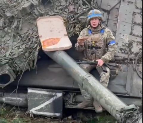 Ukranian soldier eating pizza on Russian tank CREDIT Оперативний ЗСУ.