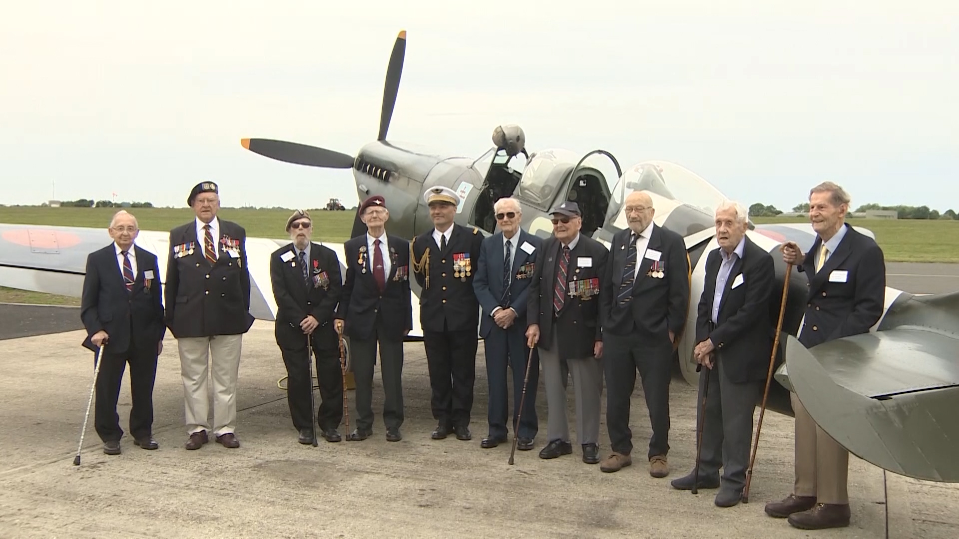 The veterans pose for a picture in front of the MJ772 Spitfire.