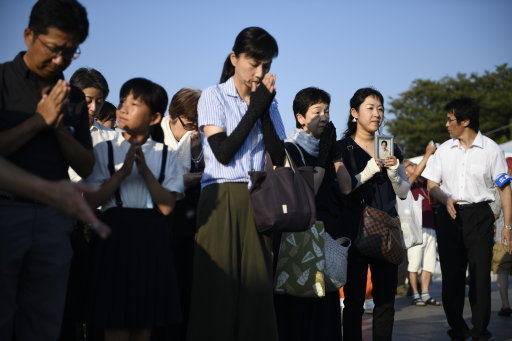 Visitors lay pray for the atomic bomb victims in front of the cenotaph at the Hiroshima Peace Memorial Park (Picture: PA).