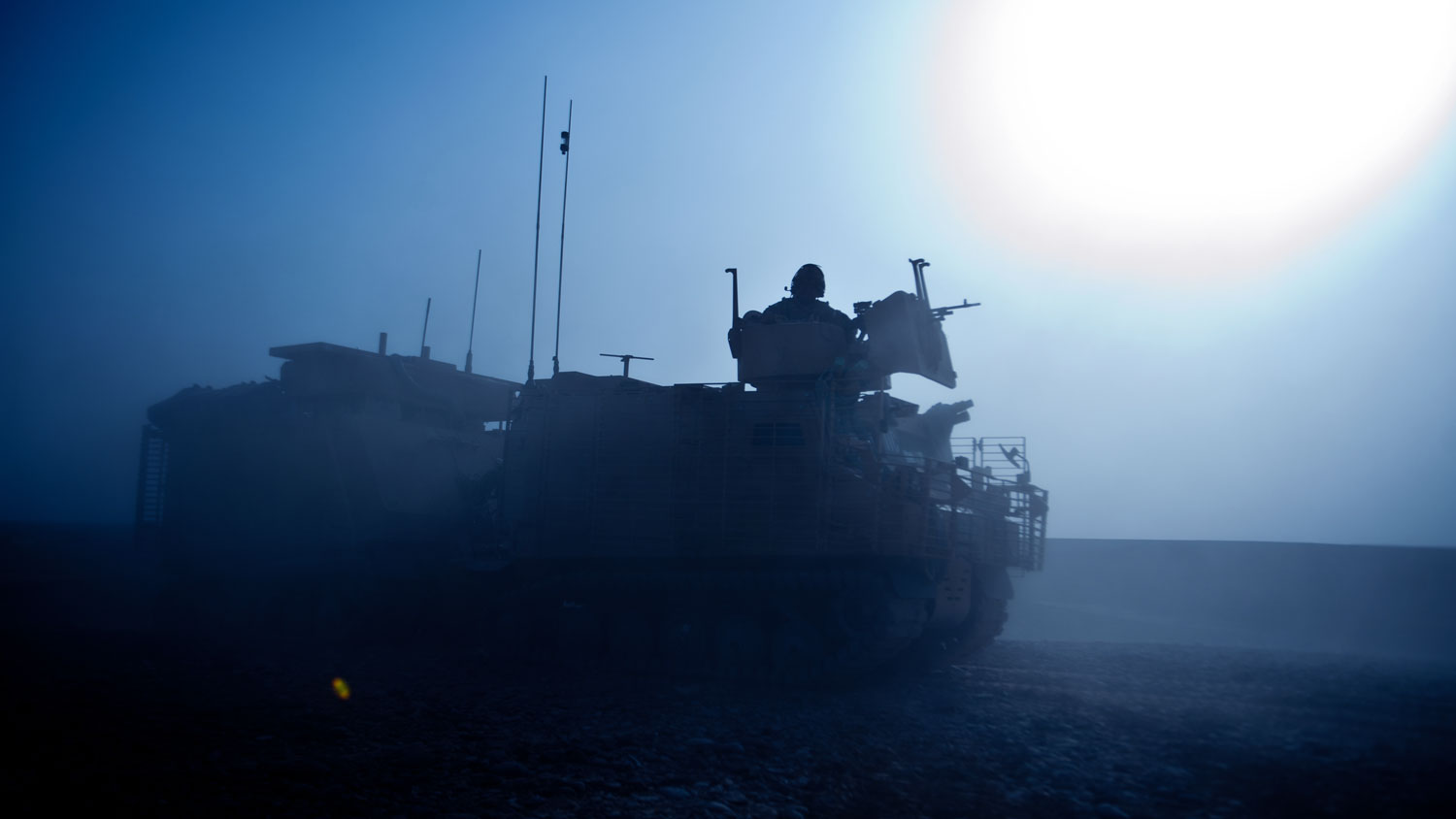 A Warthog Armoured Vehicle is silhouetted in the early morning Afghanistan sun Blue. Credit Defence Imagery