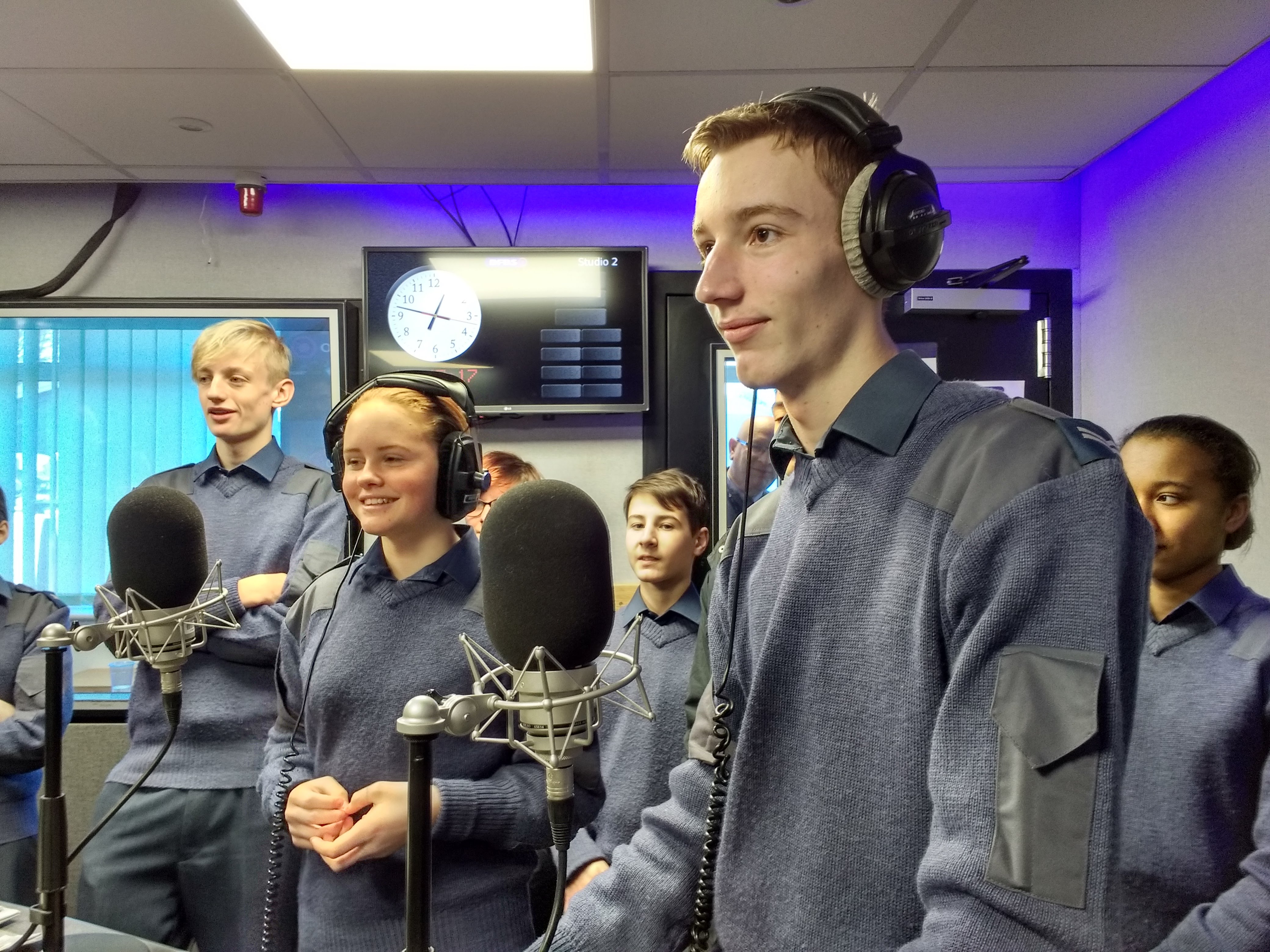 Uniformed RAF Air Cadets in headphones on the microphone in the Forces Radio BFBS studios