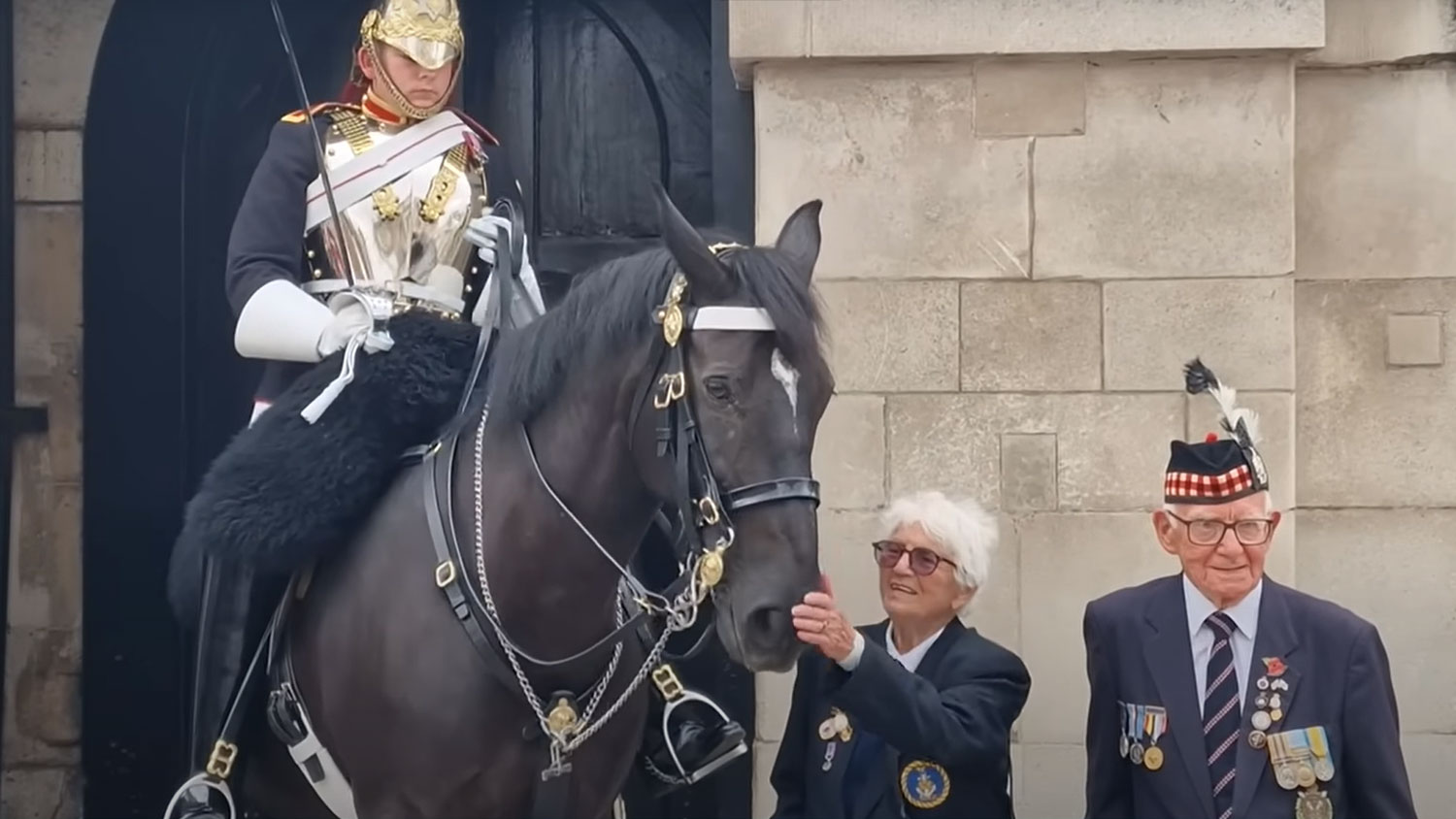 YouTube video screengrab of a Trooper posing for a photo with two veterans while conducting King's Life Guard duties at Horse Guards CREDIT Buska In The Park YouTube channel