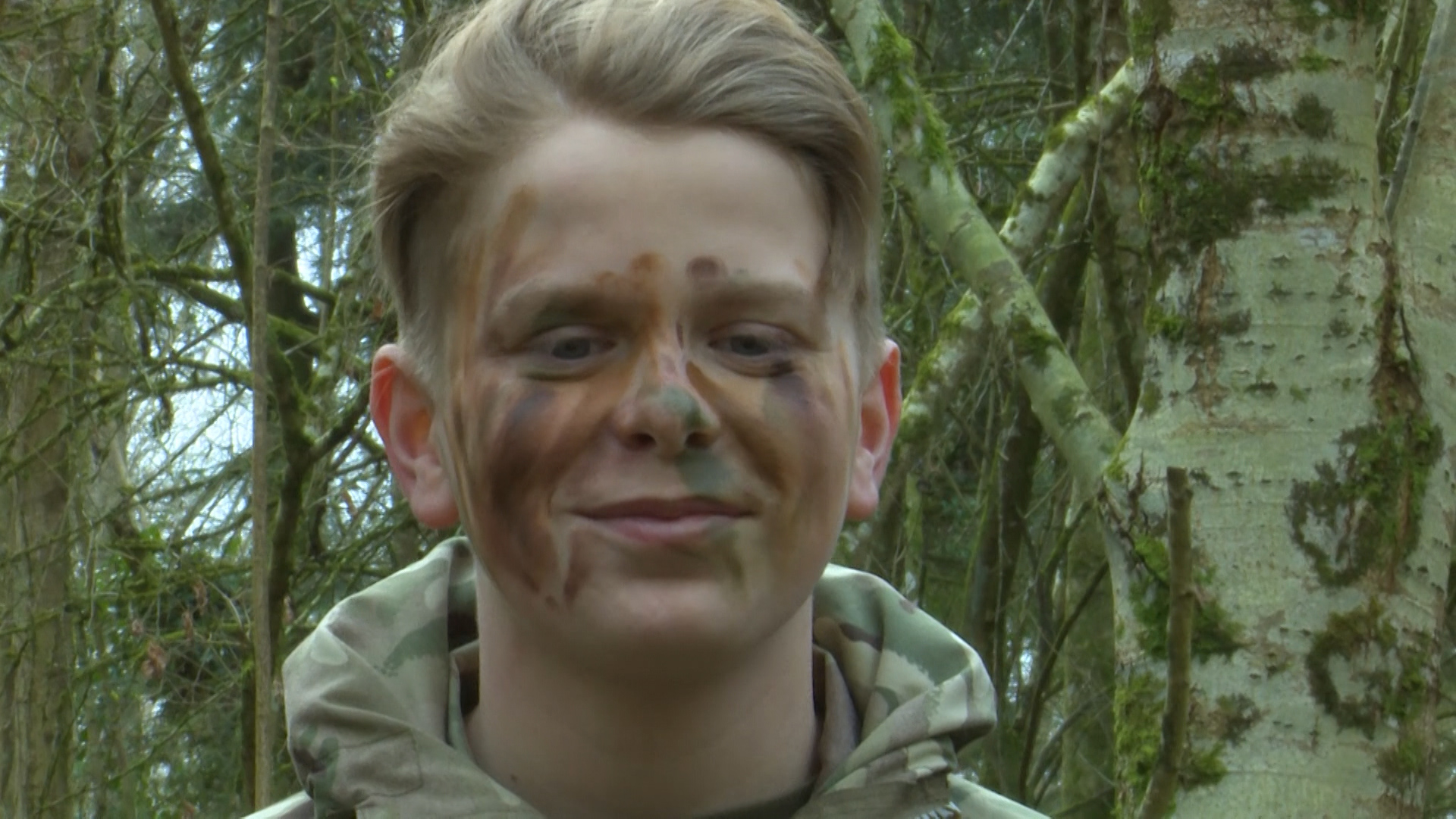 Young cadet learns how to camouflage.