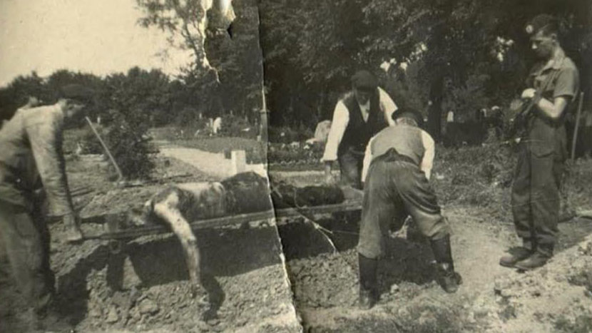 Bill Millin guarding SS prisoners and civilians burying bodies at Belsen CREDIT Bill Millin