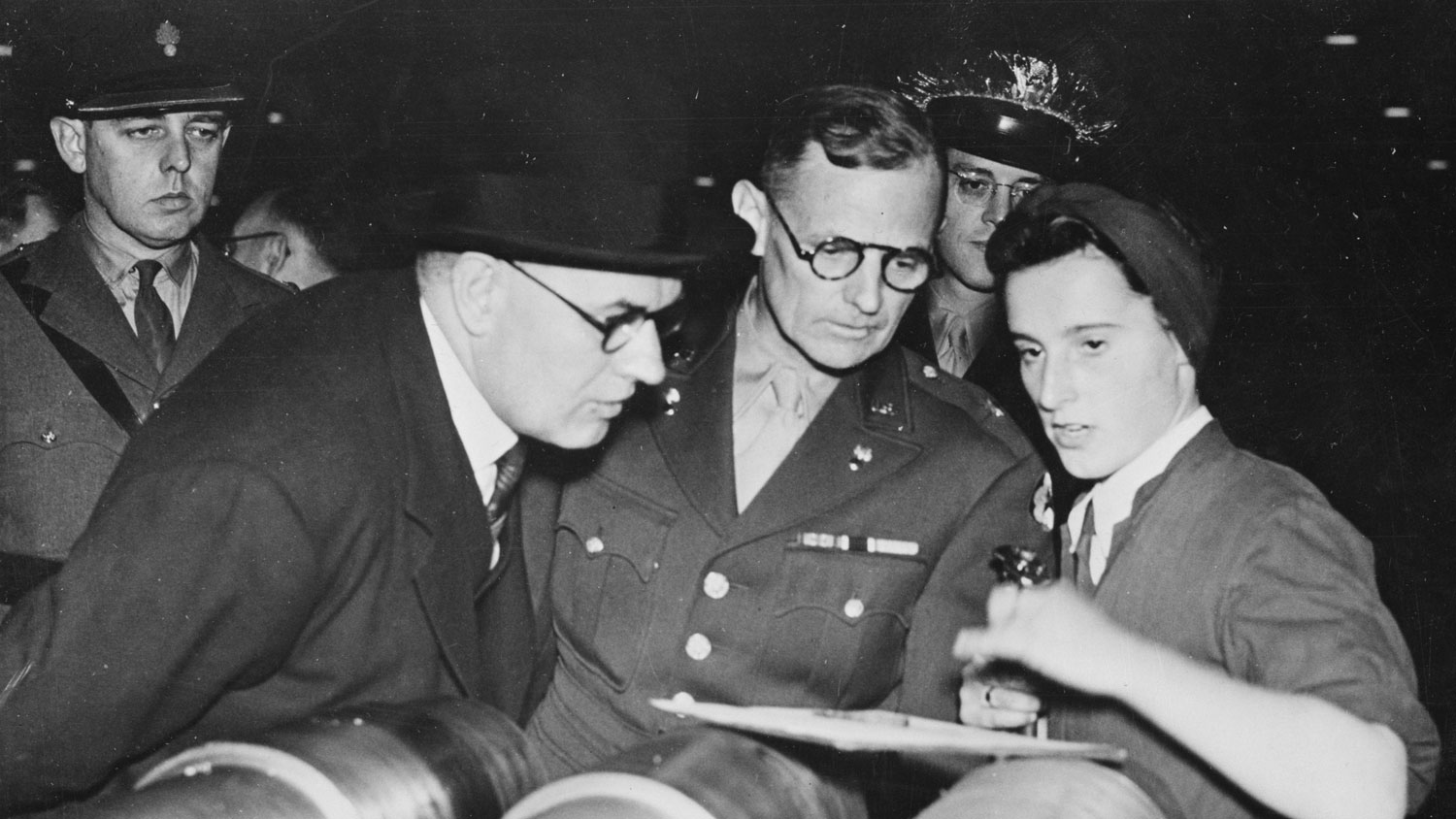 Brigadier General Barnes, centre, taking keen interest in the work of Miss Joan Leanoy who is gauging 25 pdr. gun barrels CREDIT US Library of Congress