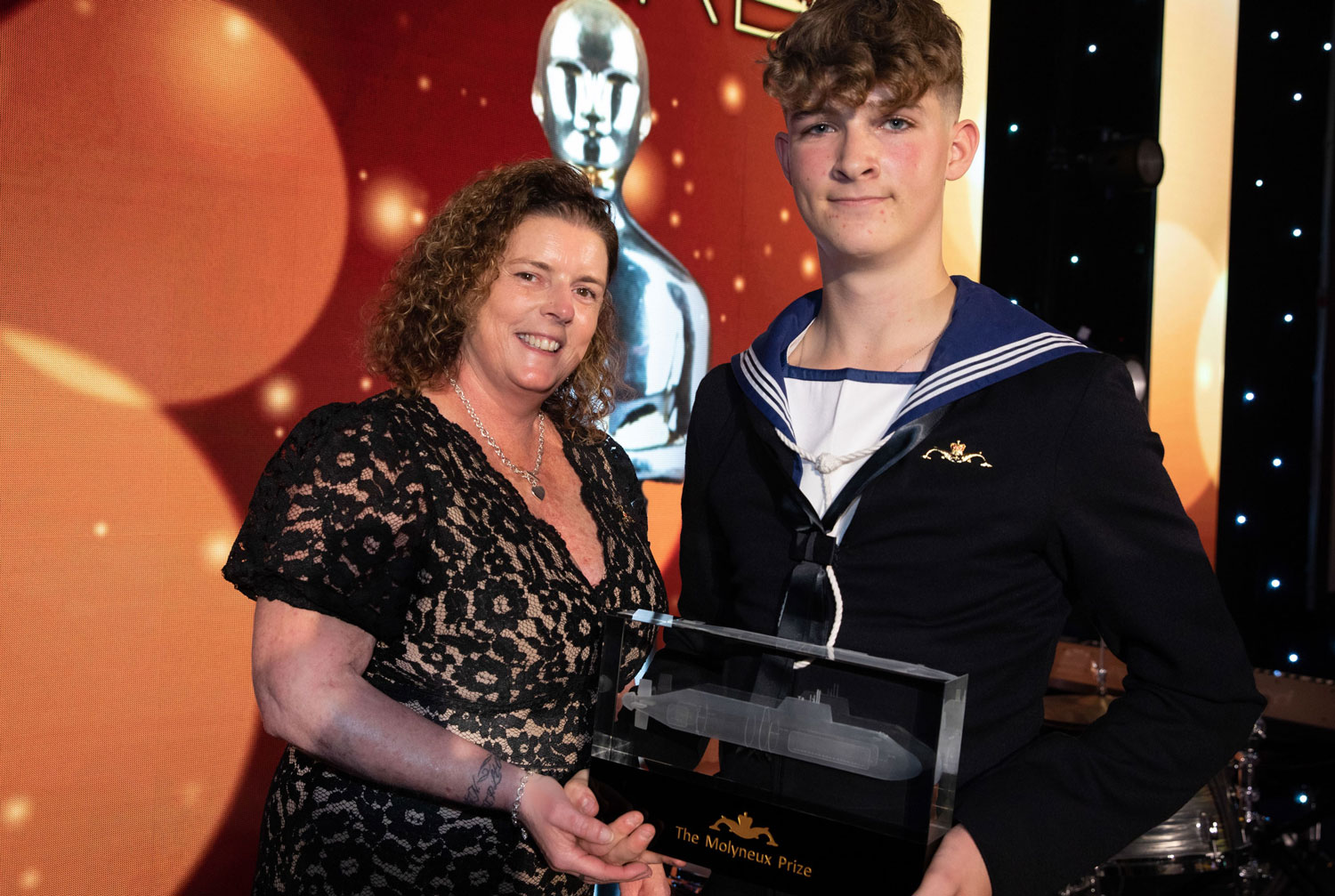 Gill Molyneux, Lt Cdr Ian Molyneux's widow, presents AB Jack Viner with his award CREDIT Royal Navy