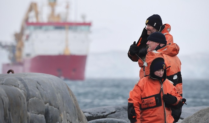 HMS Protector crew members on land with the ship in the background (Picture: Royal Navy).
