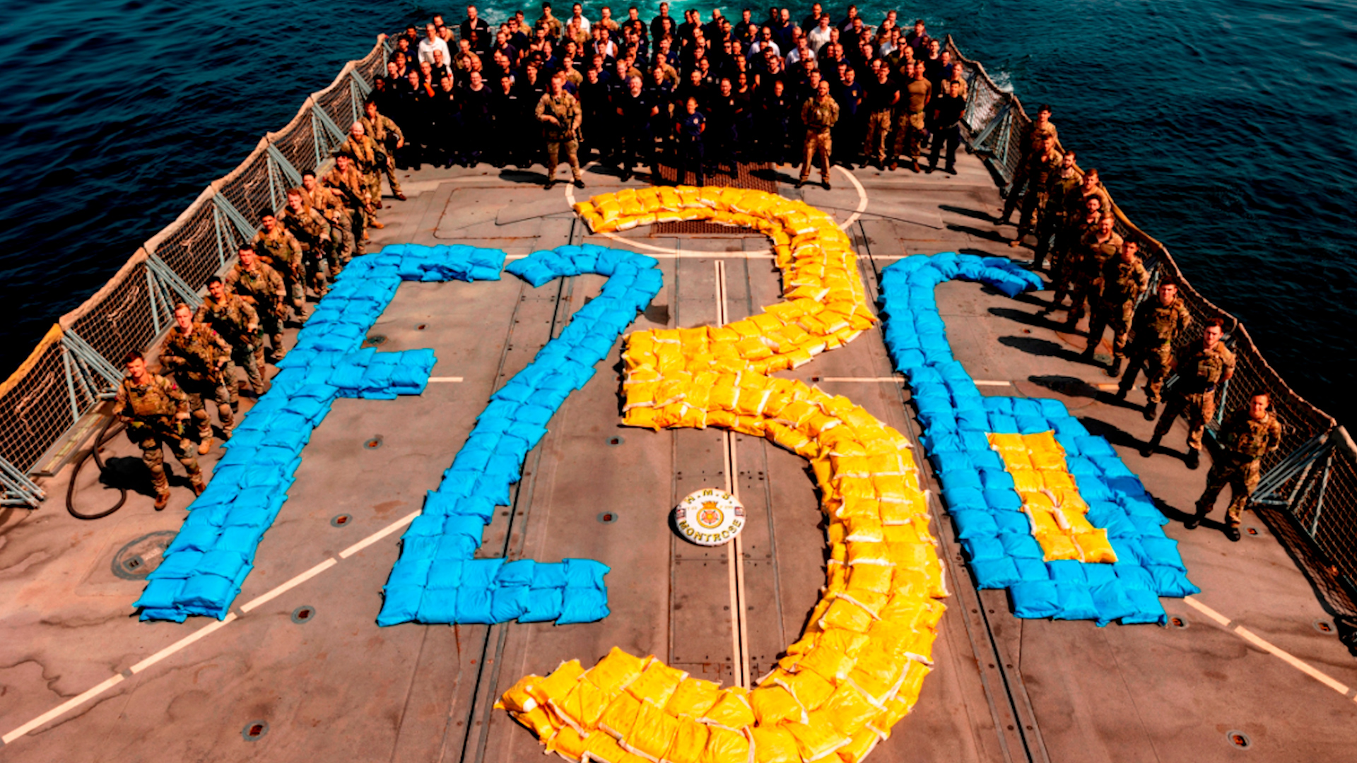 HMS Montrose's ship's company pictured with the drugs haul spelling out the ship's pennant number on the flight deck (Picture: Royal Navy).