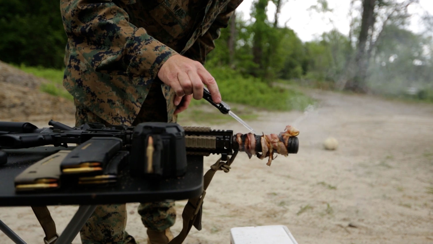 Retired US Marine Corps Chief Warrant Officer 5 Christian Wade attempts to cook bacon using the heat of his gun's suppressor 6 CREDIT US Department of Defense