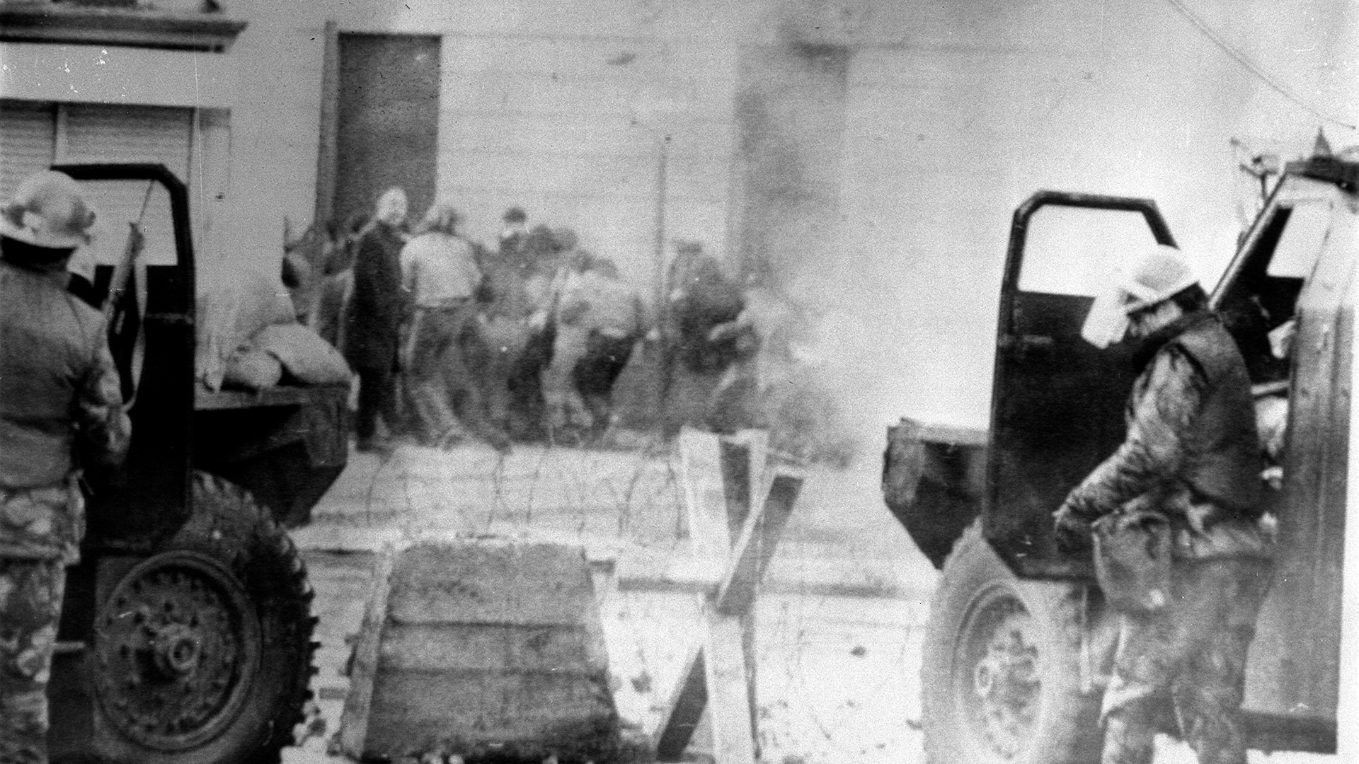 soldiers take cover behind their sandbagged armoured cars while dispersing rioters with CS gas in Londonderry 01301972 NO REUSE CREDIT PA WIRE, PA IMAGES