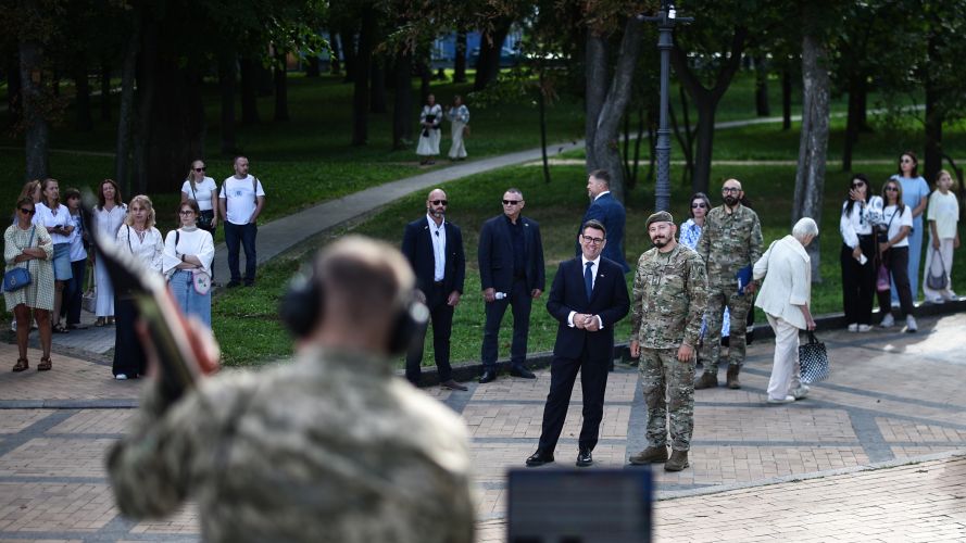 Mr Burnham, flanked by the head of the military and artistic unit which perform on the frontlines, in hospitals, and at rehabilitation, listens to member of the group Ivan Thalenko playing the electric bandura, in a park near Mykhailivska Square in Kyiv (Picture: PA) PM Andy Burnham in Kyiv Picture: PA