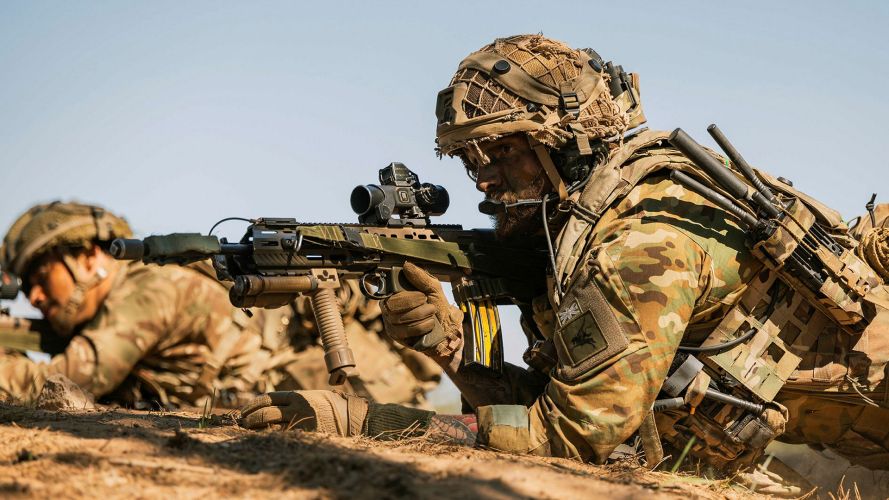  One para keeps an eye on the enemy while a fellow soldier from his section takes aim with his SA80 L85A3