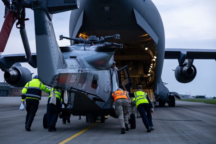 A Royal Navy Wildcat helicopter is loaded onto a RAF C-17 before it departs to bolster defences in Cyprus