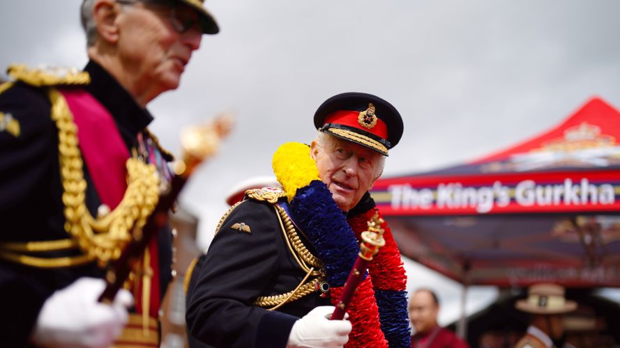 As he walked onto the red carpet, the monarch was presented with a special garland in the colours of the KGA