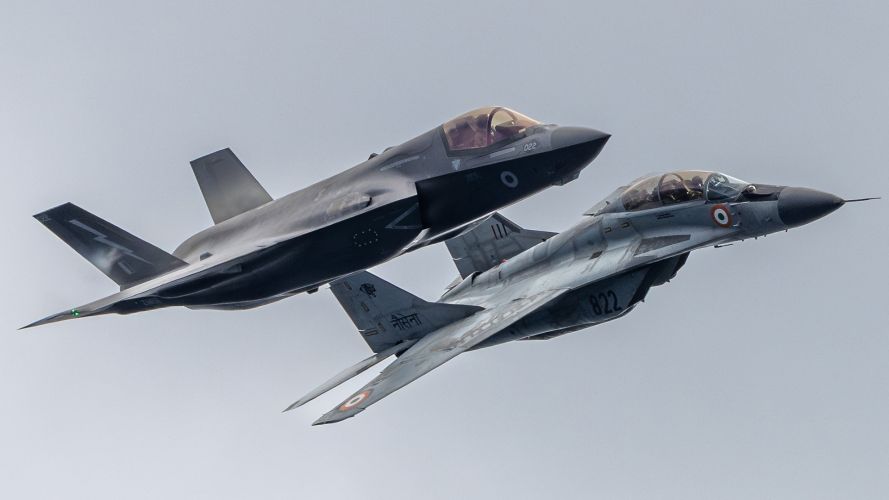 A British F-35B Lightning from HMS Prince of Wales and an Indian navy MIG-29K Fulcrum fly over the Royal Navy flagship in formation as part of Exercise Koncan during Operation Highmast