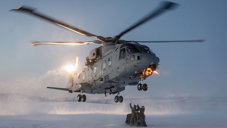 Members of the Commando Helicopter Force Mobile Air Operations Team wait to attach an underslung load to a Merlin Mk4 from 845 Naval Air Squadron in northern Norway