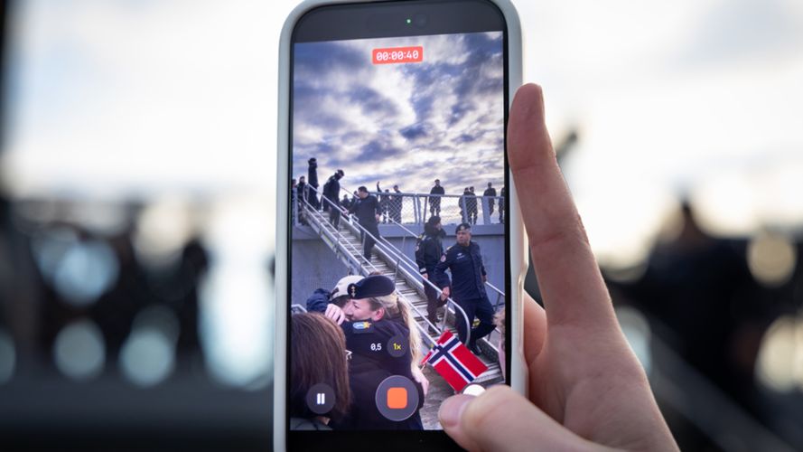 Someone captures the moment the personnel disembark the vessel on their phone (Picture: Edward Valentin Coates/Forsvaret) Someone captures the moment the personnel disembark the vessel on their phone