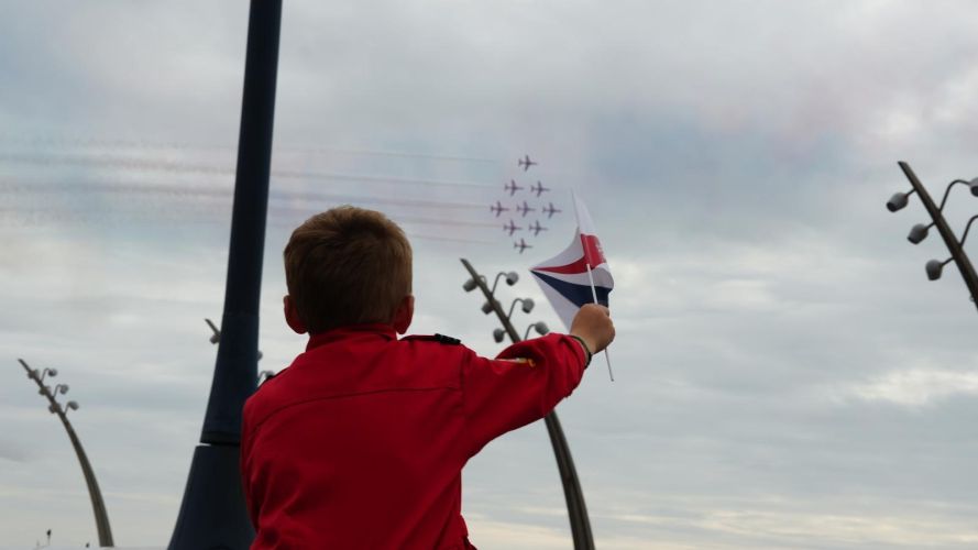 A flag-waving youngster watches the Red Arrows over Blackpool's seafront (Picture: Red Arrows X)  Red Arrows at Blackpool Air Show Crwedit: Red Arrows X)