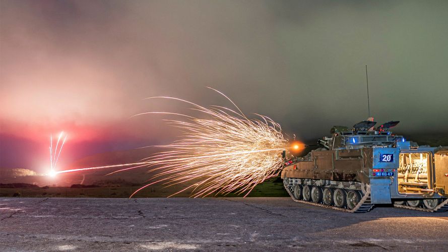 A Warrior IFV opens fire with its 7.62mm chain gun during a gunnery course to qualify personnel as Armoured Cavalry Troop Leaders or Warrior Platoon Commanders - note how the spent cases are ejected forwards