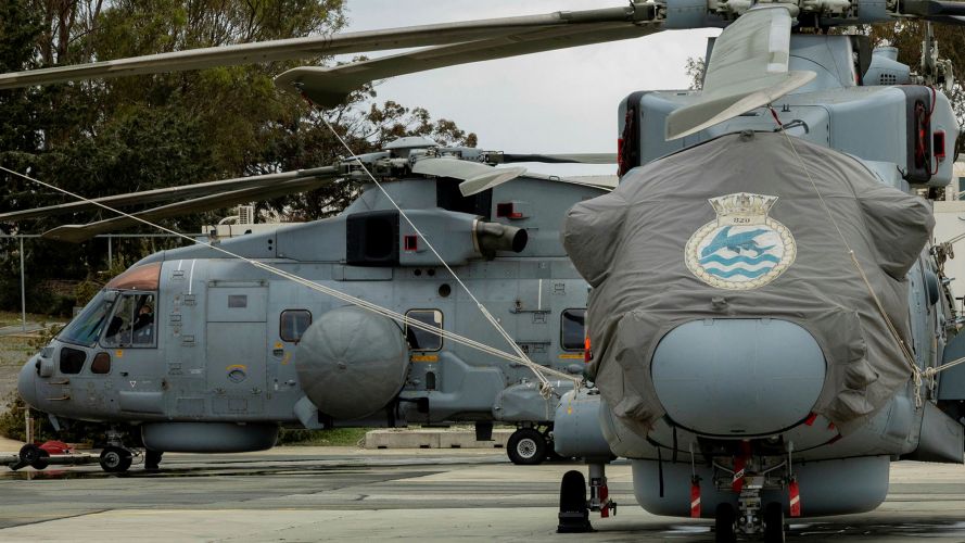 Merlin Crowsnest airborne surveillance and control system helicopters await their next mission while deployed to RAF Akrotiri - the helicopters are from 820 Naval Air Squadron, whose emblem is a flying fish