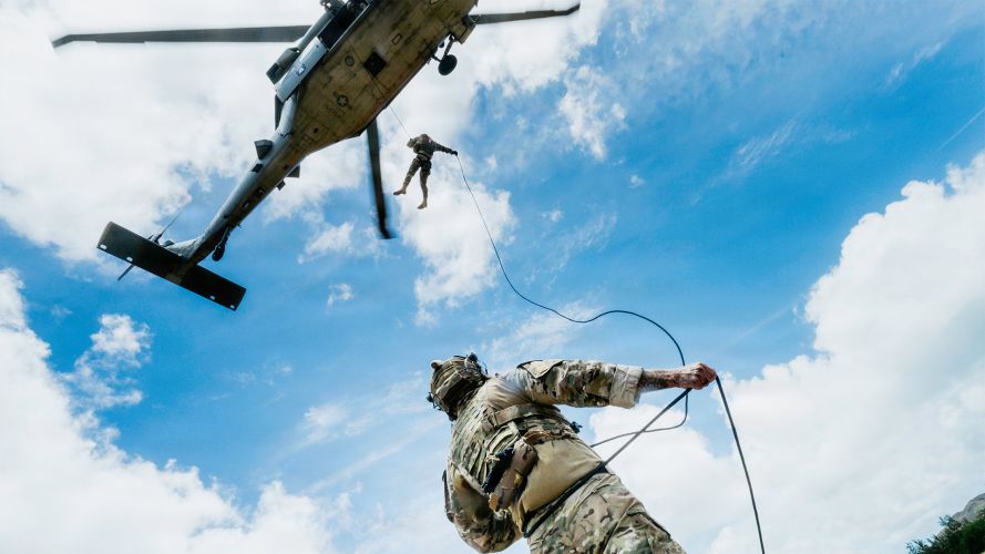 A US Navy explosive ordnance disposal technician secures a rope on the ground for a Peruvian navy counterpart descending from an SH-60 Sea Hawkat Bellows Air Force Station A US Navy explosive ordnance disposal technician secures a rope on the ground for a Peruvian navy counterpart descending from an SH-60 Sea Hawkat Bellows Air Force Station