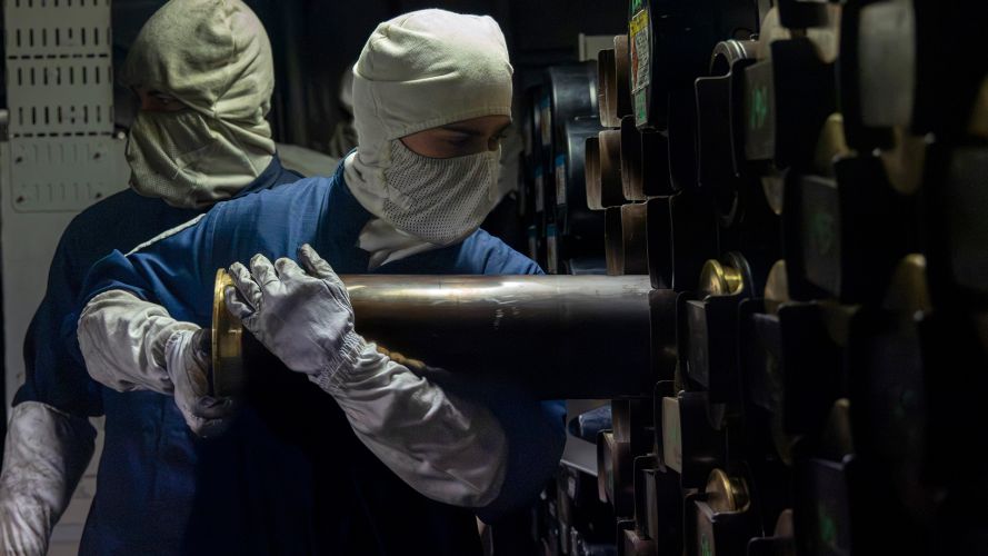 A member of the 4.5" gun bay team takes a round from the magazine as destroyer HMS Duncan prepares to carry out gun support drills during Exercise Sharpshooter