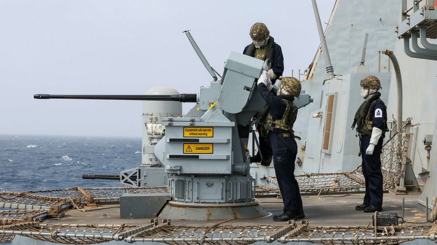 Personnel wearing protective clothing operate one of the 30mm Small Calibre Guns during live firing gunnery serials on board HMS Dragon - the crew also tested the Phalanx close-in weapon systems