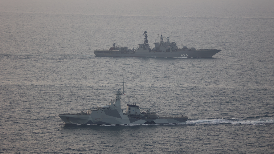 HMS Trent wears a modern dazzle camouflage paint scheme while shadowed Russian vessel in UK waters 