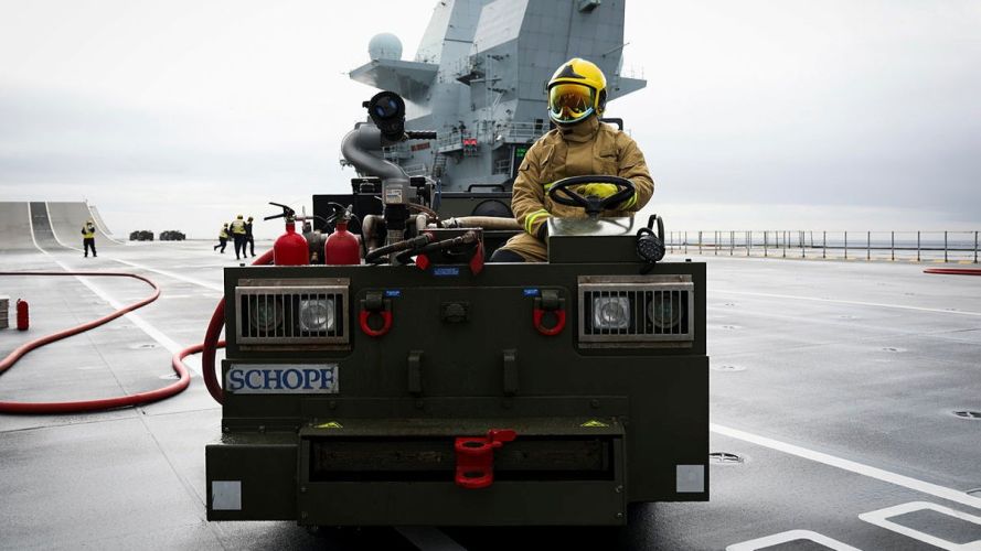 A Royal Navy firefighter mans a flight deck tractor during the crash-on-deck drill (Picture: MOD) HMS Queen Elizabeth crash-on-deck exercise