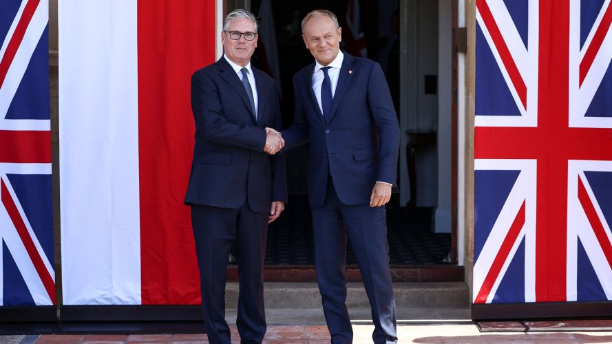 The pair shake hands beside the Union Jack and the Polish flag (Picture: PA)