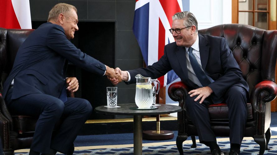 The duo shake hands across a table at the meeting (Picture: PA)