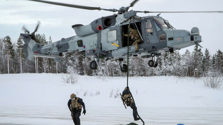 Personnel fast rope with their kit and rifle, replicating a real scenario