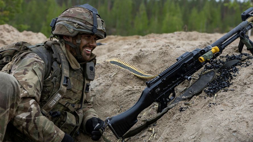 A GPMG gunner from 3 Para shares a joke while manning his firing position alongside soldiers from Finland's Kainuu Brigade on Exercise Northern Star, less than 80 miles from the Russian border