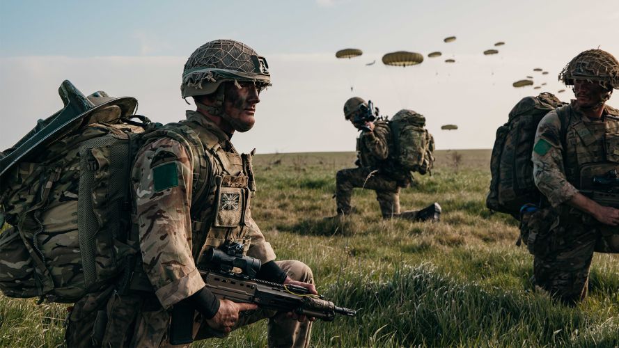 Soldiers from 3rd Battalion, The Parachute Regiment prepare to patrol off the drop zone after jumping from an RAF A400M Atlas during a Joint Airborne Task Force exercise on Salisbury Plain