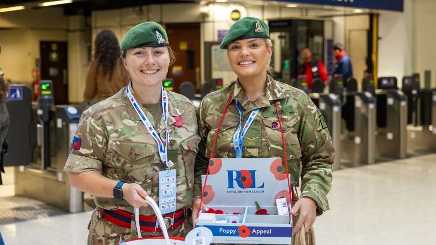 Corporal Kriehn and Lance Corporal Pike of the Staff and Personnel Support Branch - a large part of the Adjutant General's Corps - sell poppies at Marylebone Station in London