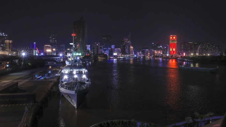 HMS Spey lit up at Saigon Port with the skyline of Ho Chi Minh City in the background pic MOD