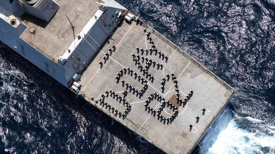 The ship's company forms up on the flight deck on board HMS Dragon to commemorate the 82nd Anniversary of the D-Day Landings in Normandy in June 1944